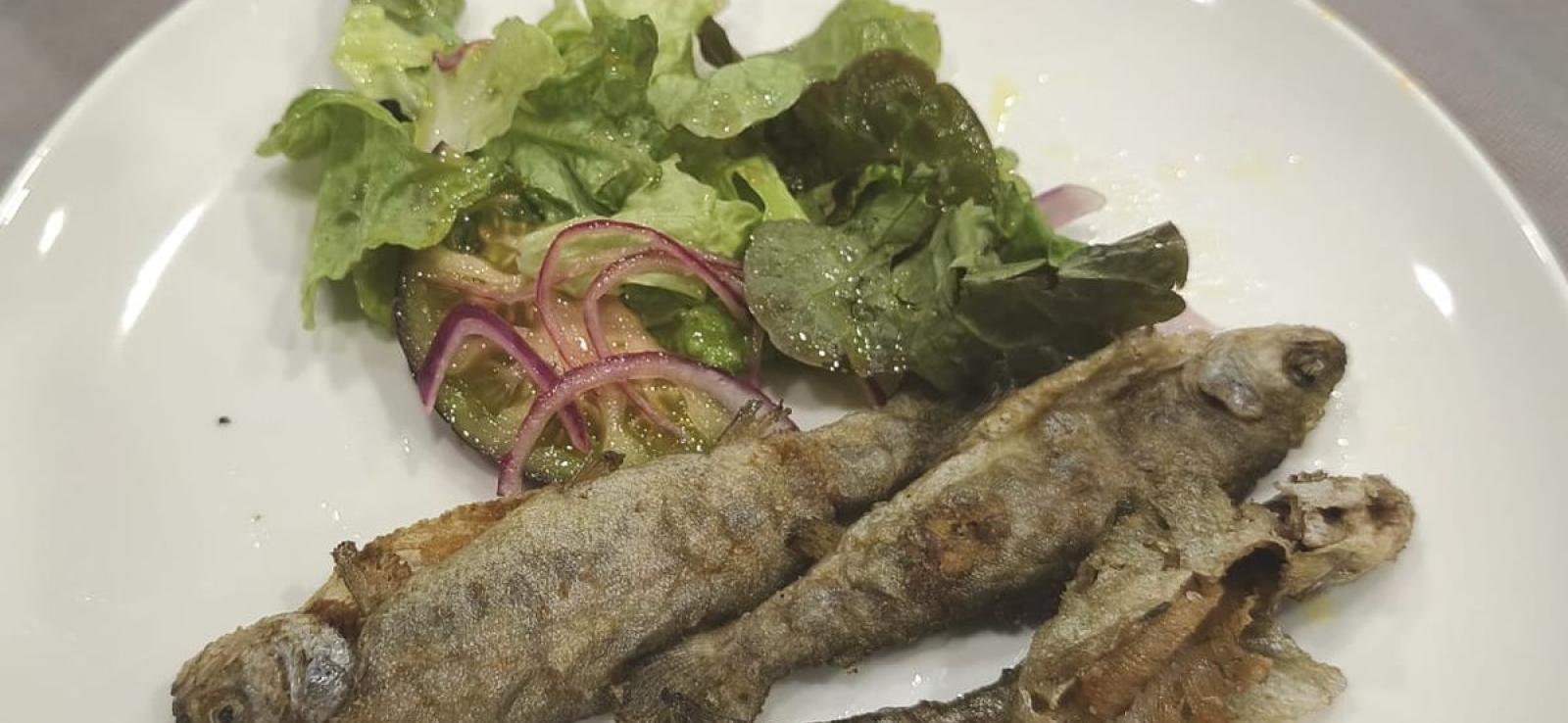 Truchas fritas con ensalada de tomate negro y lechugas variadas